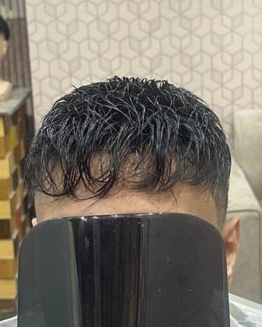 شعر داكن قصير بملمس مموج وتصفيف مرتب لعميل بعد تركيب نظام الشعر