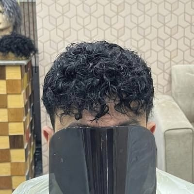 شعر كيرلي داكن بخصلات واضحة لعميل بعد تركيب نظام الشعر وتصفيفه